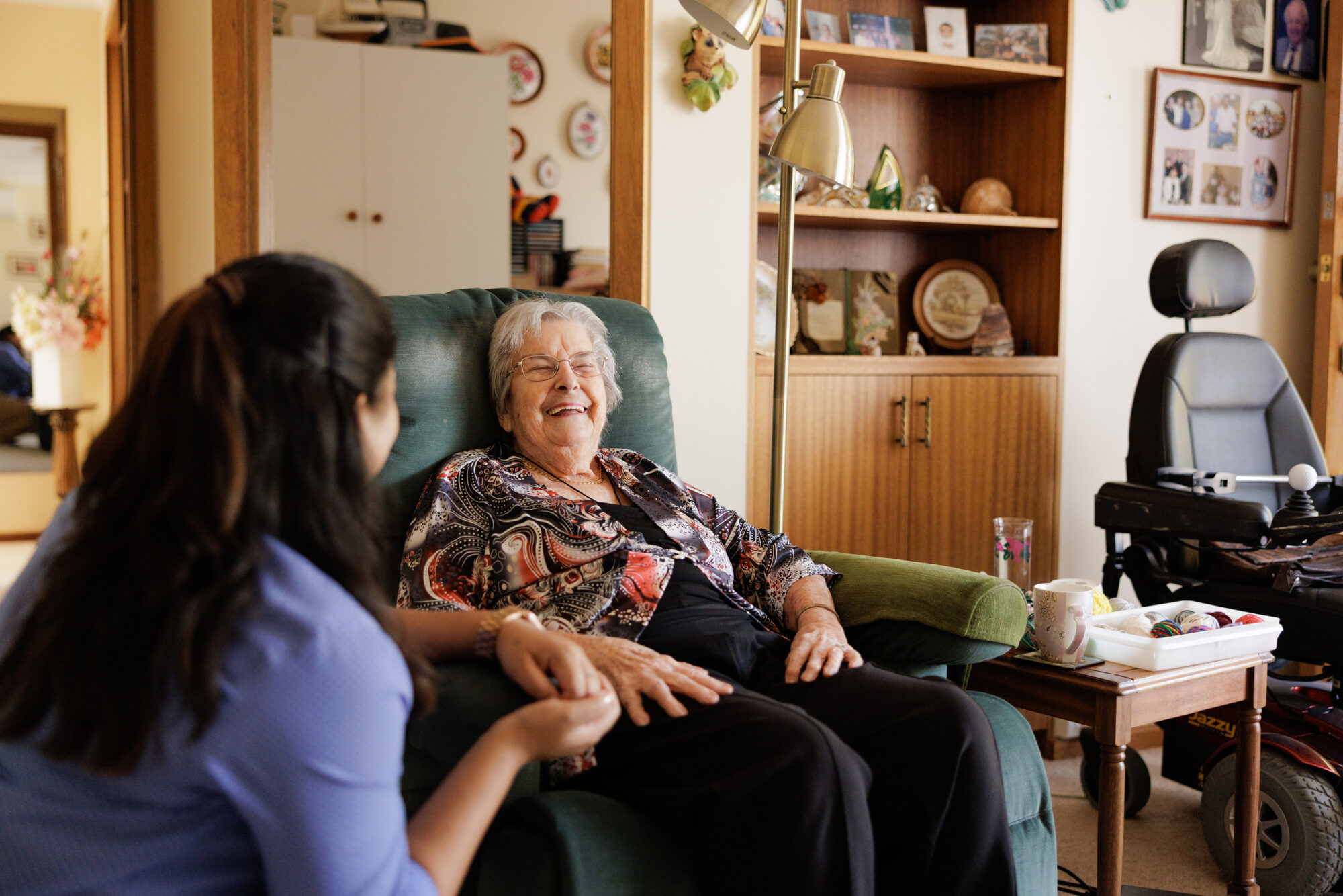 A care assistant laughing warmly with a resident.