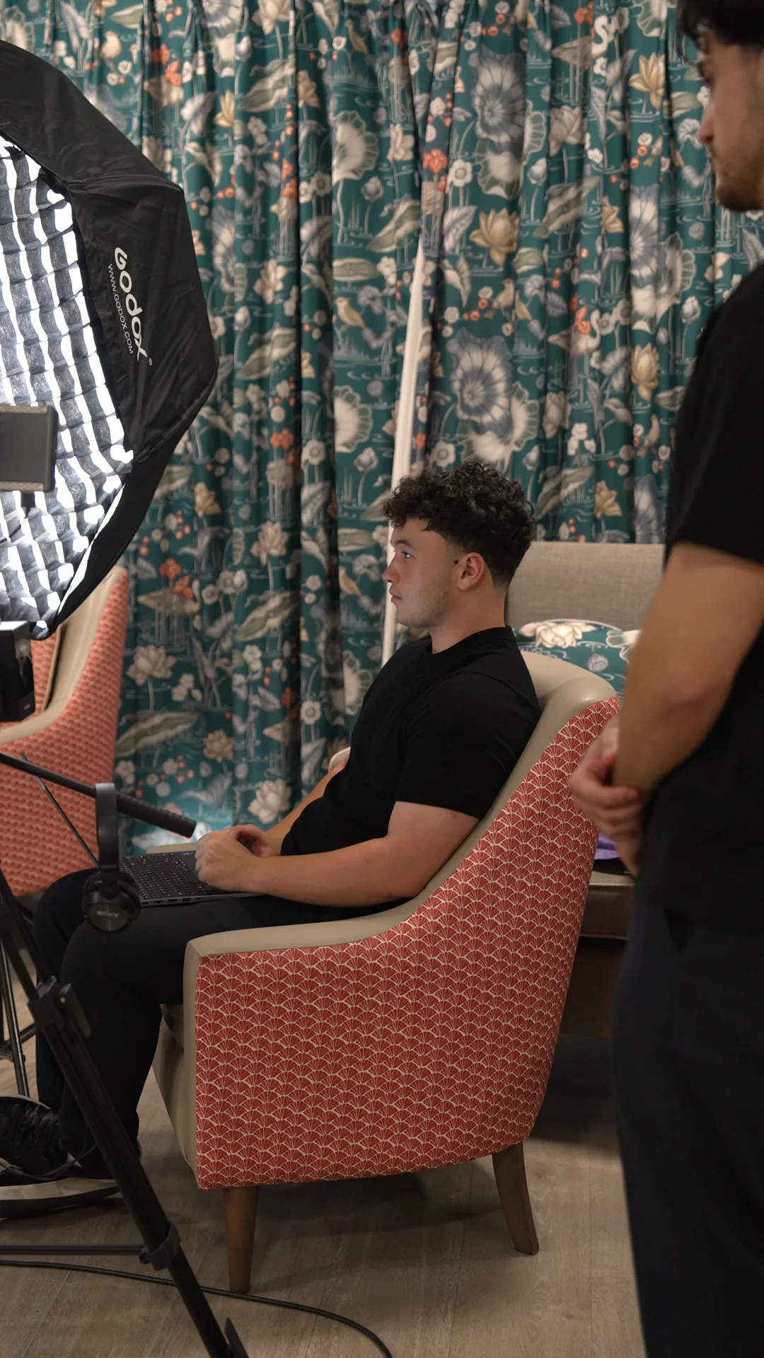 An editor reviewing the day's footage on a laptop at the home.